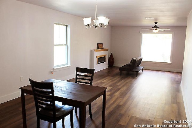 dining space featuring ceiling fan with notable chandelier and dark hardwood / wood-style floors