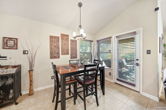 dining area with light tile patterned floors, vaulted ceiling, an inviting chandelier, and a healthy amount of sunlight