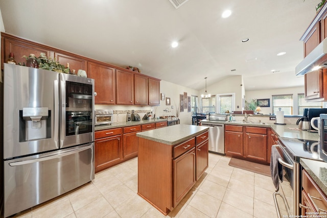 kitchen featuring stainless steel appliances, decorative light fixtures, a notable chandelier, a kitchen island, and lofted ceiling