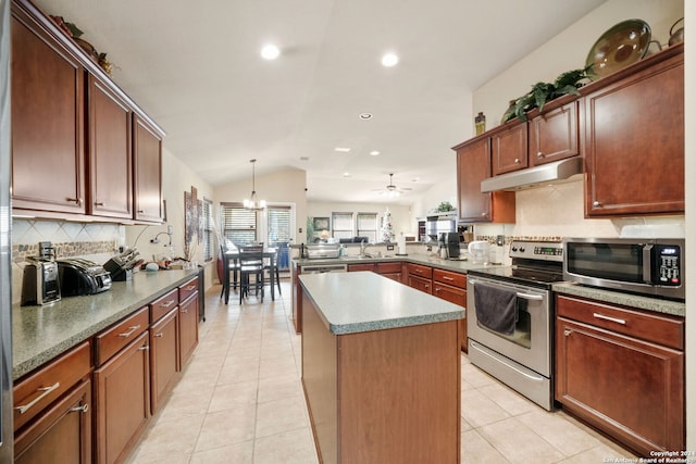 kitchen with pendant lighting, a center island, ceiling fan with notable chandelier, vaulted ceiling, and appliances with stainless steel finishes