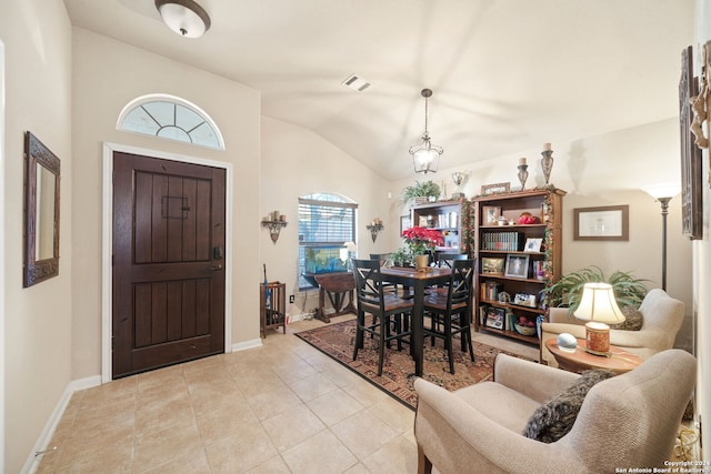 entryway featuring light tile patterned flooring and vaulted ceiling