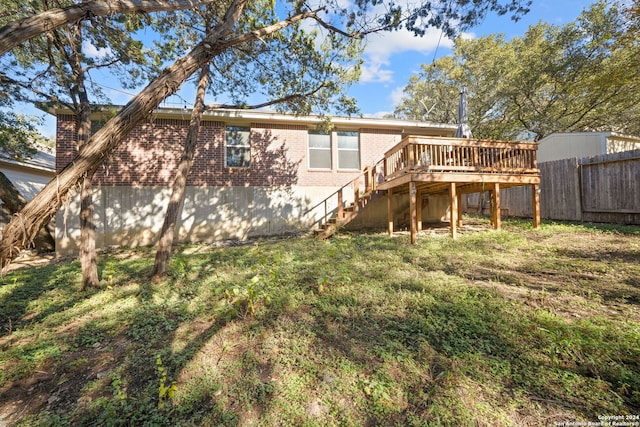 back of house featuring a lawn and a wooden deck