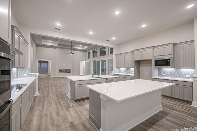 kitchen featuring a center island, light hardwood / wood-style flooring, stainless steel appliances, and sink