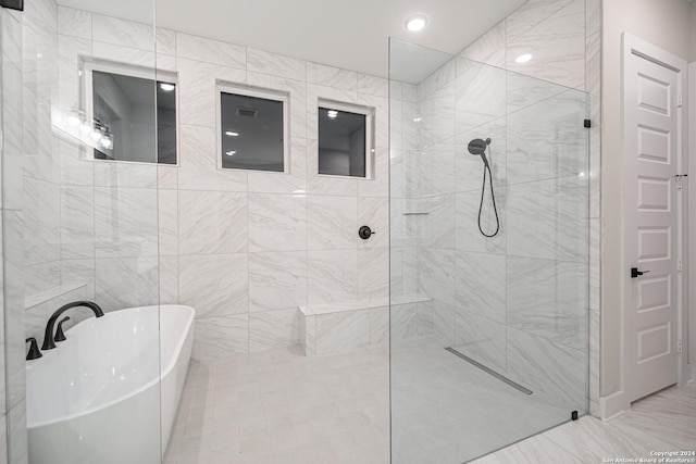 bathroom featuring separate shower and tub and tile walls