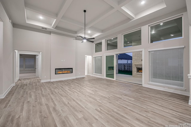 unfurnished living room with ceiling fan, light hardwood / wood-style floors, and coffered ceiling