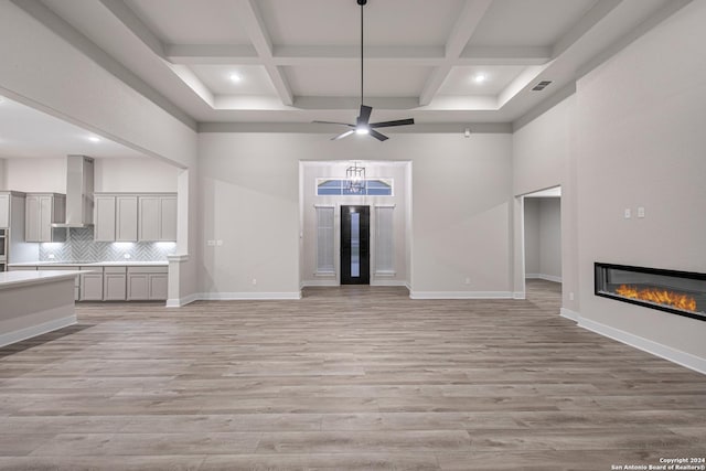 unfurnished living room featuring light hardwood / wood-style floors and coffered ceiling