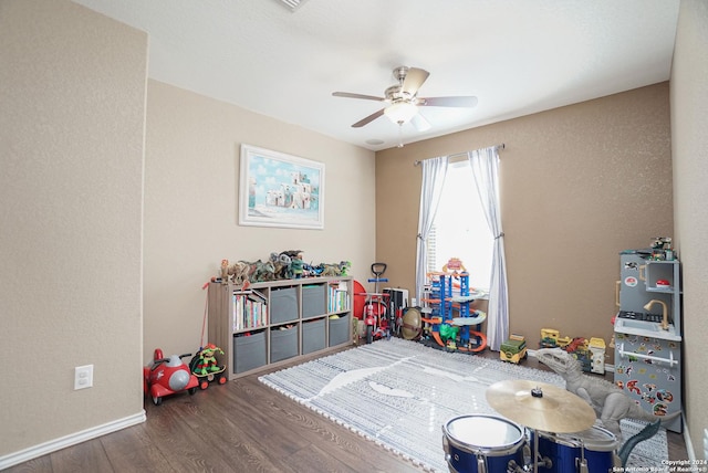 rec room with dark hardwood / wood-style floors and ceiling fan