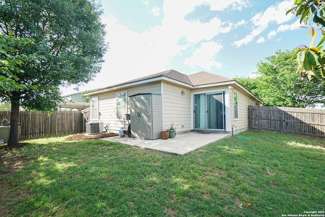 rear view of property with a lawn, a patio area, and central air condition unit