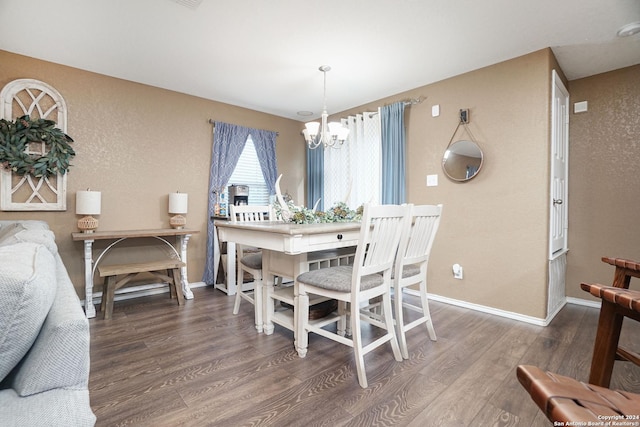 dining area featuring dark hardwood / wood-style flooring and an inviting chandelier