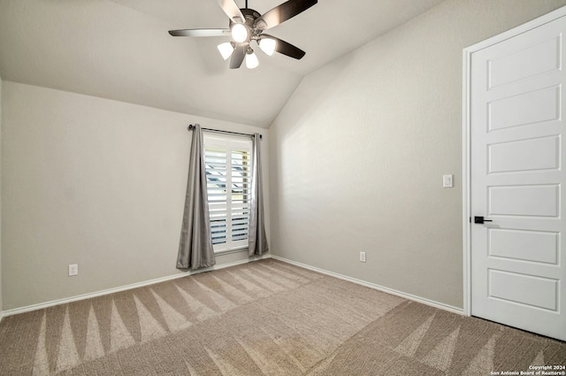 carpeted empty room with ceiling fan and lofted ceiling