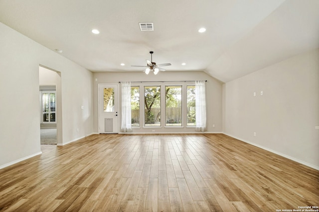 unfurnished living room featuring ceiling fan, plenty of natural light, lofted ceiling, and light wood-type flooring