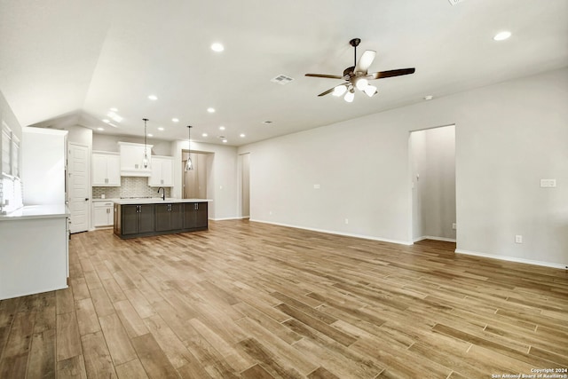 unfurnished living room featuring ceiling fan, light hardwood / wood-style floors, lofted ceiling, and sink