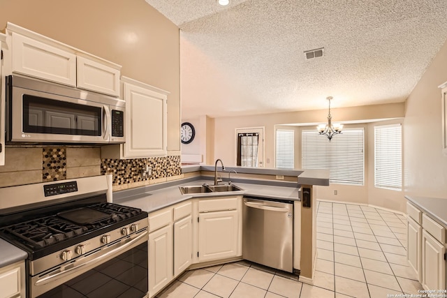 kitchen featuring appliances with stainless steel finishes, tasteful backsplash, sink, decorative light fixtures, and white cabinetry