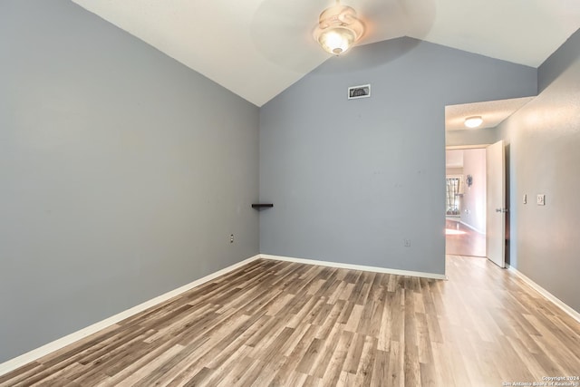 empty room with hardwood / wood-style floors and lofted ceiling