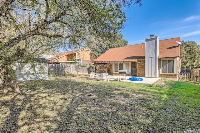 back of house with a patio area and a yard