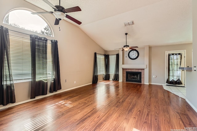 unfurnished living room with a healthy amount of sunlight, lofted ceiling, and hardwood / wood-style flooring