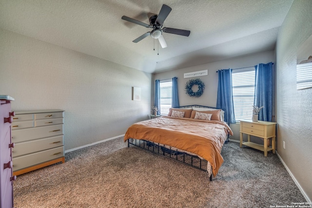 carpeted bedroom with a textured ceiling, multiple windows, and ceiling fan