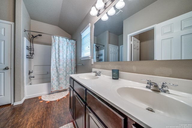 bathroom featuring shower / bath combo, hardwood / wood-style floors, a textured ceiling, vaulted ceiling, and vanity