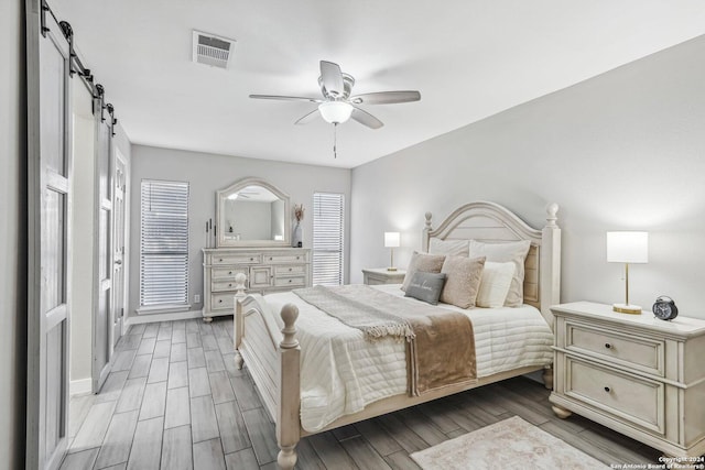 4911 Dare, San Antonio, TX 78217 - bedroom featuring a barn door, ceiling fan, and wood-type flooring