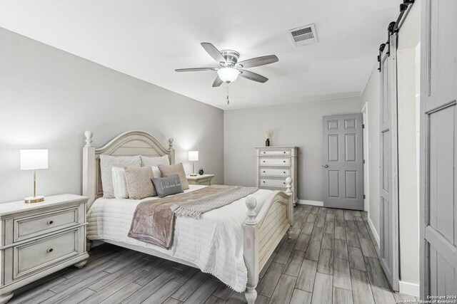 4911 Dare, San Antonio, TX 78217 - bedroom with a barn door, hardwood / wood-style flooring, and ceiling fan