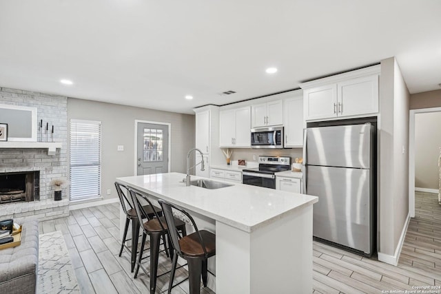 4911 Dare, San Antonio, TX 78217 - kitchen with a breakfast bar, white cabinets, sink, light hardwood / wood-style floors, and stainless steel appliances