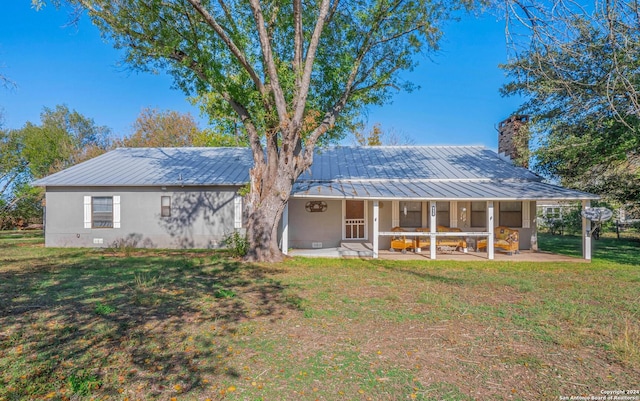 rear view of property featuring a patio, a lawn, and a sunroom