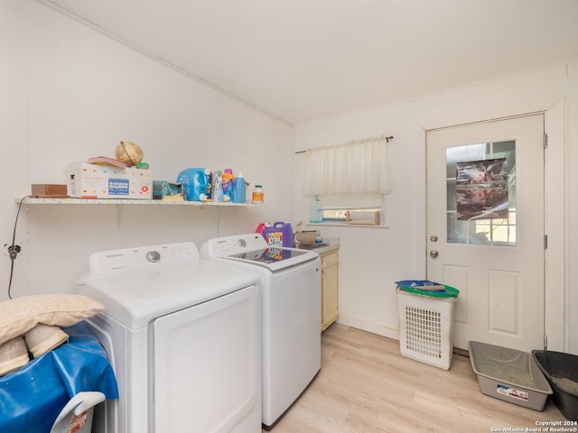 laundry area featuring light hardwood / wood-style floors, cabinets, and washing machine and clothes dryer