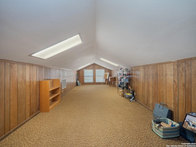 bonus room featuring wood walls, light colored carpet, and lofted ceiling