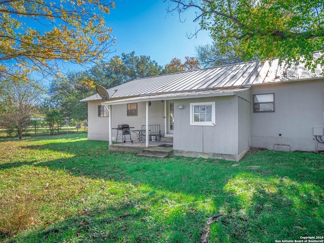 rear view of house featuring a patio area and a lawn