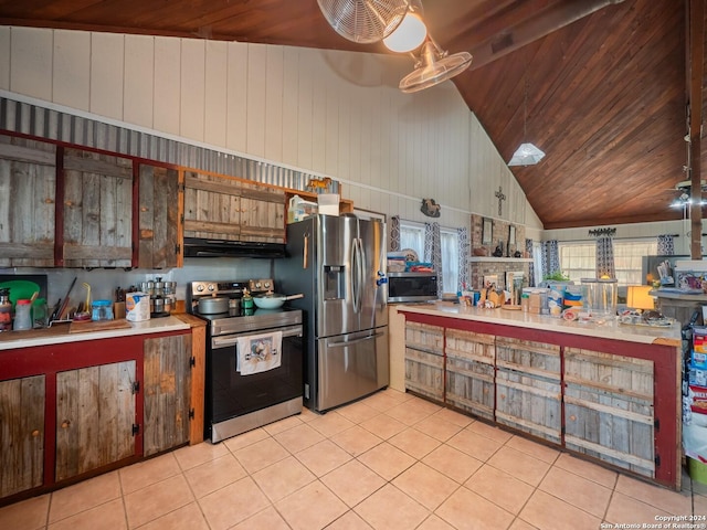 kitchen featuring light tile patterned floors, wood ceiling, stainless steel appliances, and wooden walls