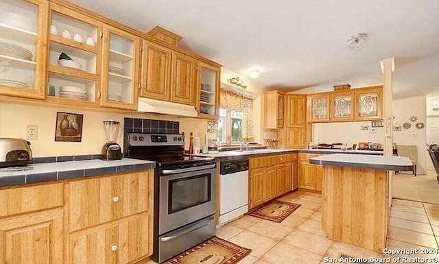 kitchen with stainless steel range with electric stovetop, tile countertops, a center island, white dishwasher, and light tile patterned flooring