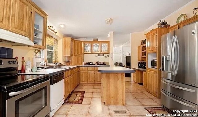 kitchen featuring sink, a kitchen island, light tile patterned floors, and appliances with stainless steel finishes