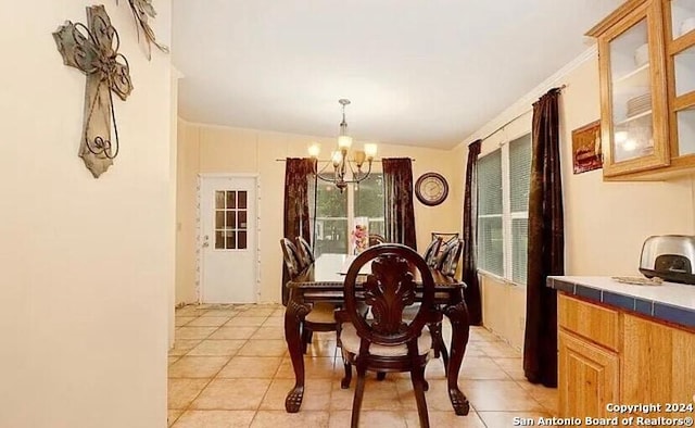 dining area with light tile patterned floors, vaulted ceiling, and a notable chandelier