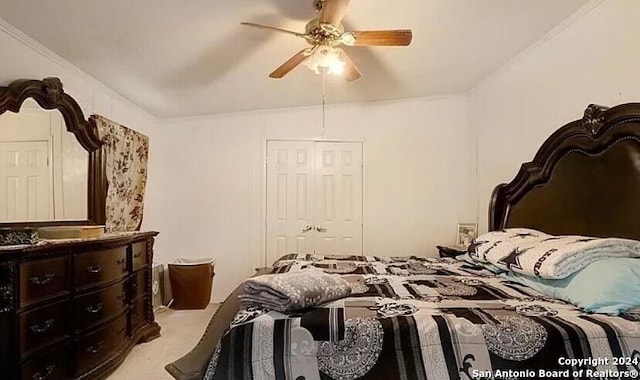 carpeted bedroom featuring ceiling fan, ornamental molding, and a closet