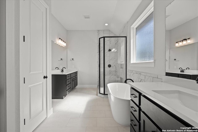 bathroom featuring shower with separate bathtub, vanity, and tile patterned floors