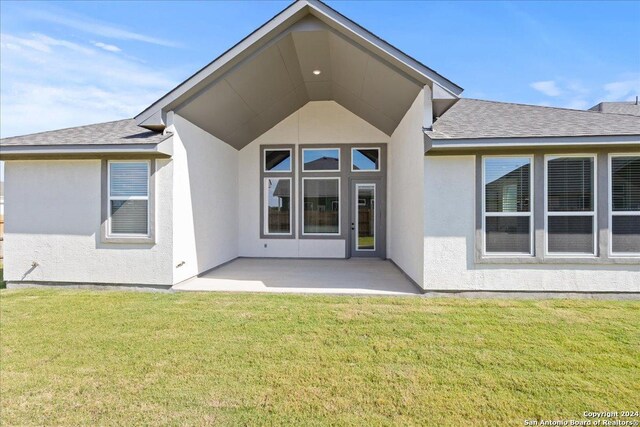 back of house with a lawn and a patio