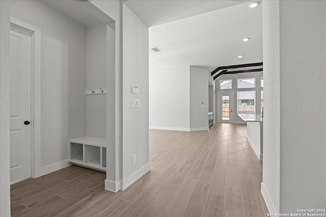 hallway with light wood-type flooring and a textured ceiling