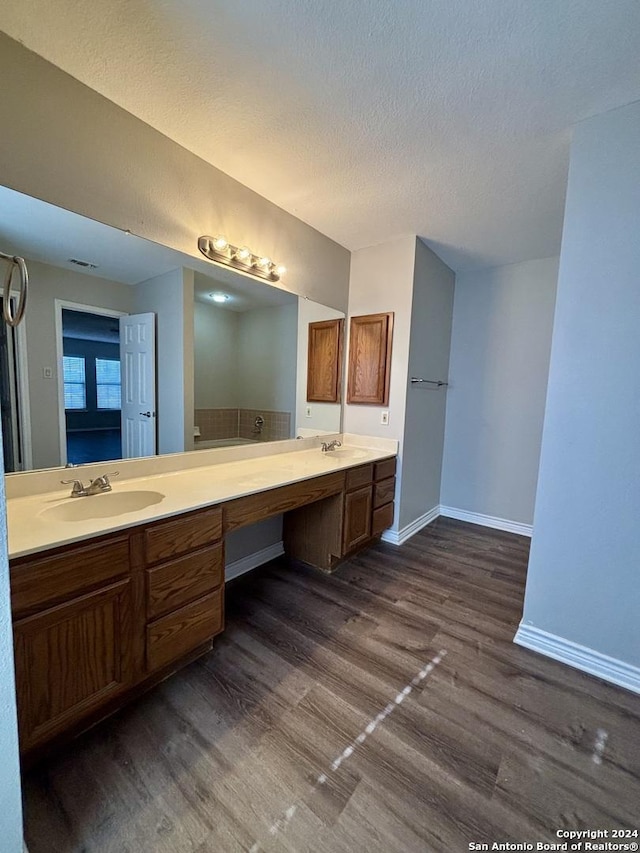 bathroom featuring hardwood / wood-style floors, vanity, and a textured ceiling