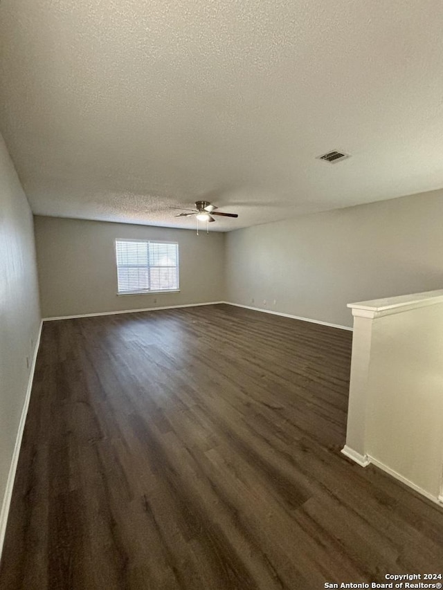 spare room featuring ceiling fan, dark hardwood / wood-style flooring, and a textured ceiling