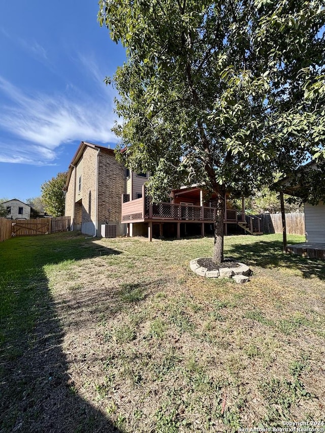 view of yard with central AC and a deck