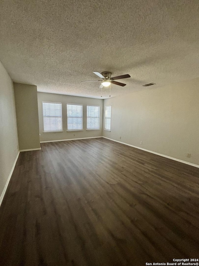 empty room with ceiling fan and a textured ceiling