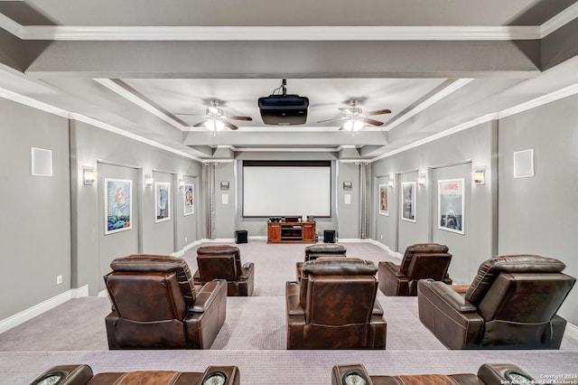 cinema with ceiling fan, a raised ceiling, ornamental molding, and carpet floors