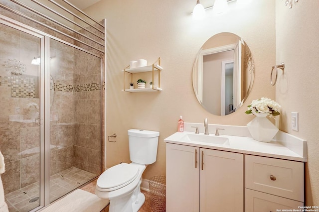 bathroom featuring vanity, toilet, and a shower with shower door