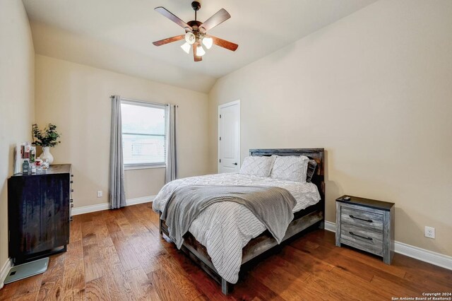 bedroom with dark hardwood / wood-style flooring, ceiling fan, and lofted ceiling