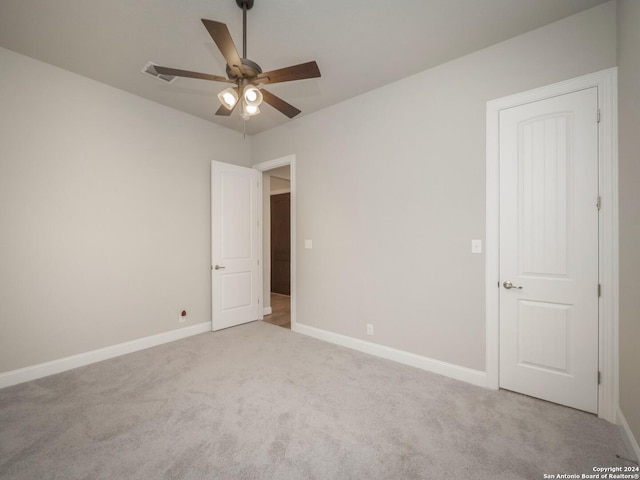 carpeted spare room with ceiling fan