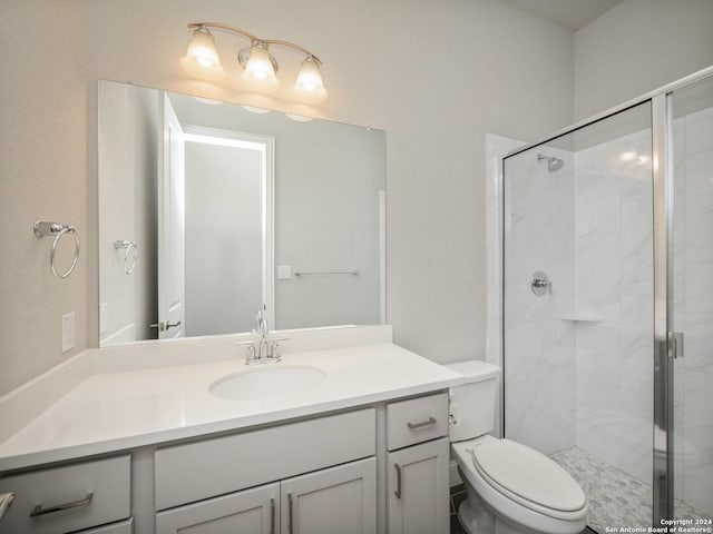 bathroom with toilet, vanity, and walk in shower