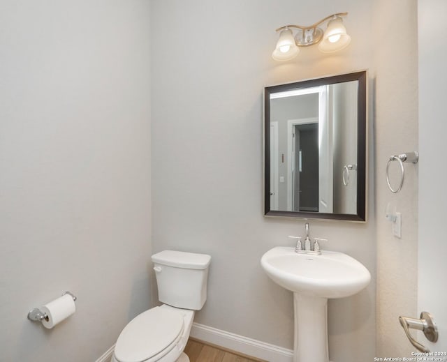 bathroom featuring wood-type flooring and toilet