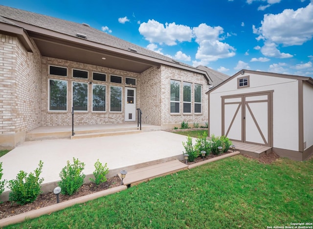 rear view of house with a yard and a storage unit