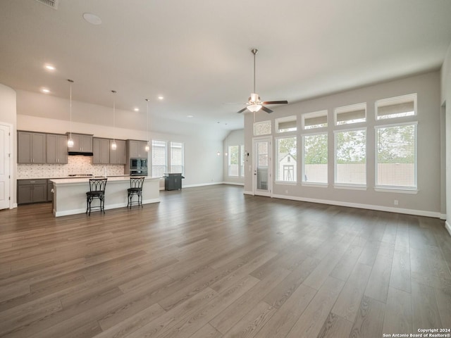 unfurnished living room with ceiling fan and dark wood-type flooring