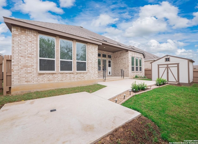 rear view of house with a lawn, a shed, and a patio